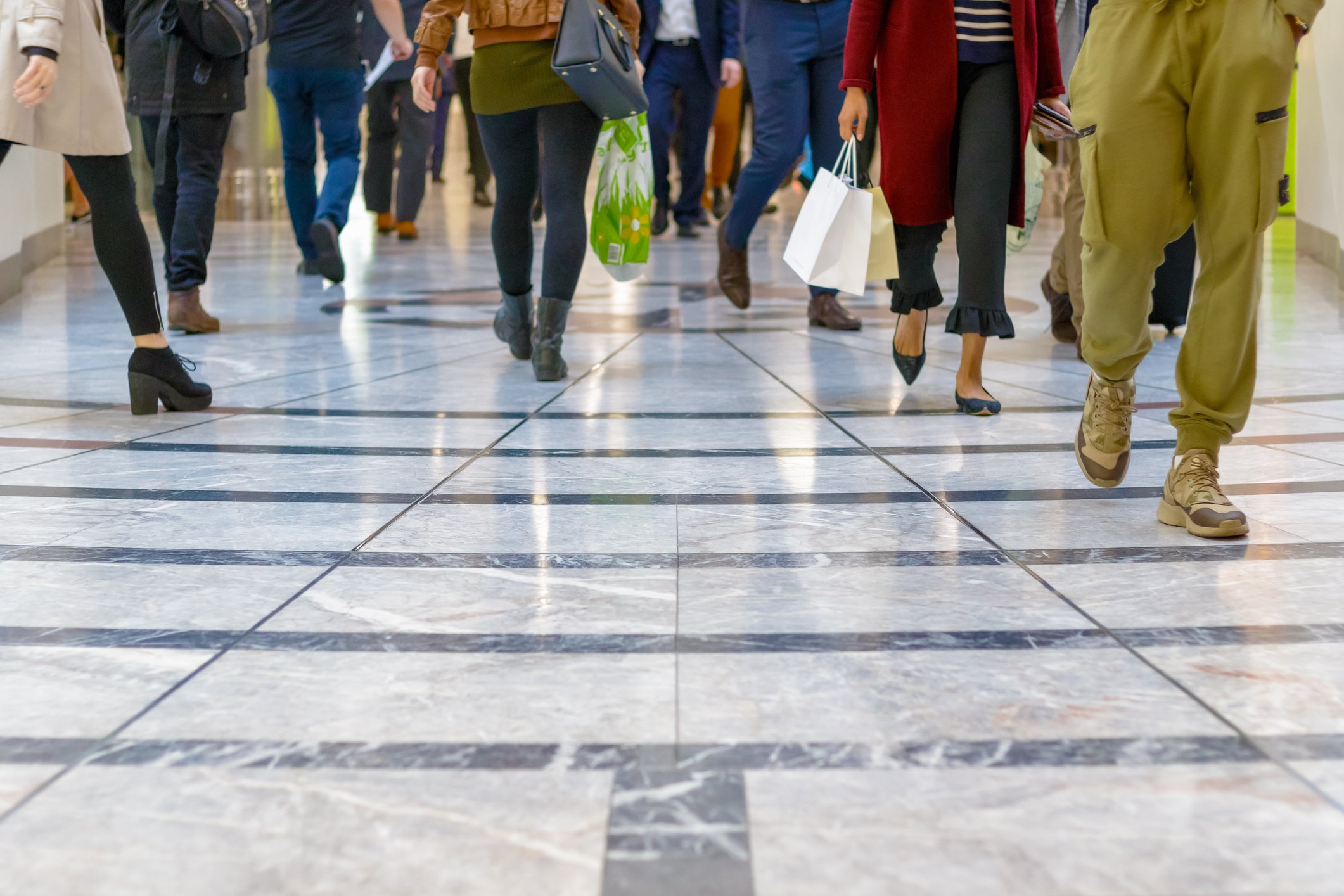 Image of shoppers walking in a crowded mall corridor.