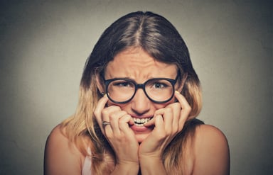 Woman biting fingernails in worry