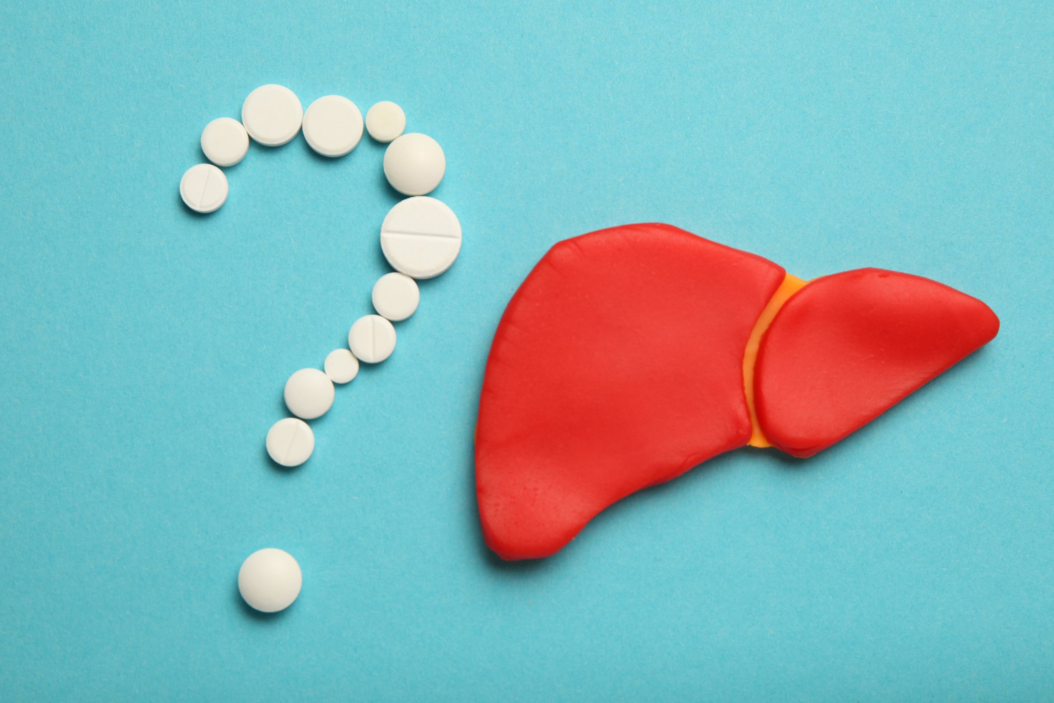 Pills in shape of question mark next to liver image