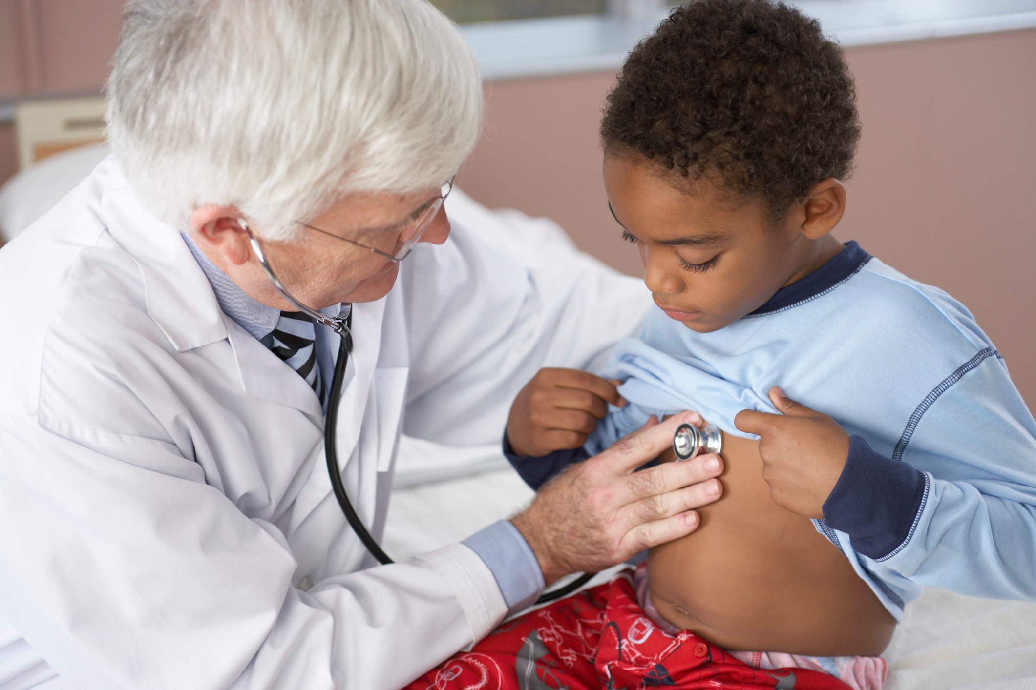 Doctor using a stethoscope on a boy's chest.