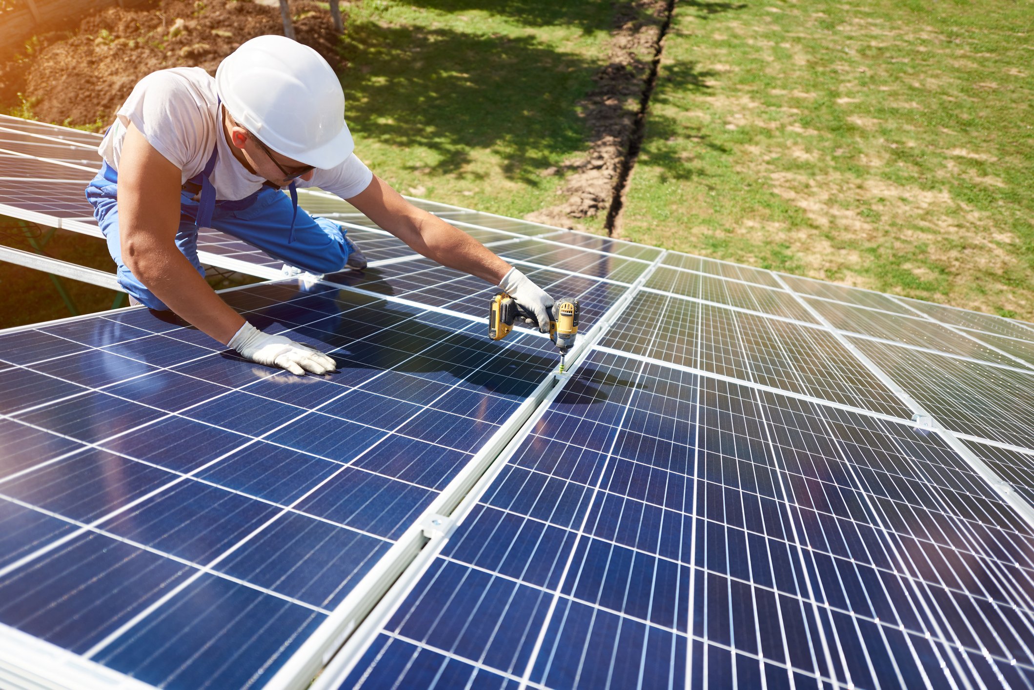 A worker installs a rooftop solar panel array.