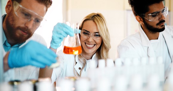 Three scientists in lab working with test tubes