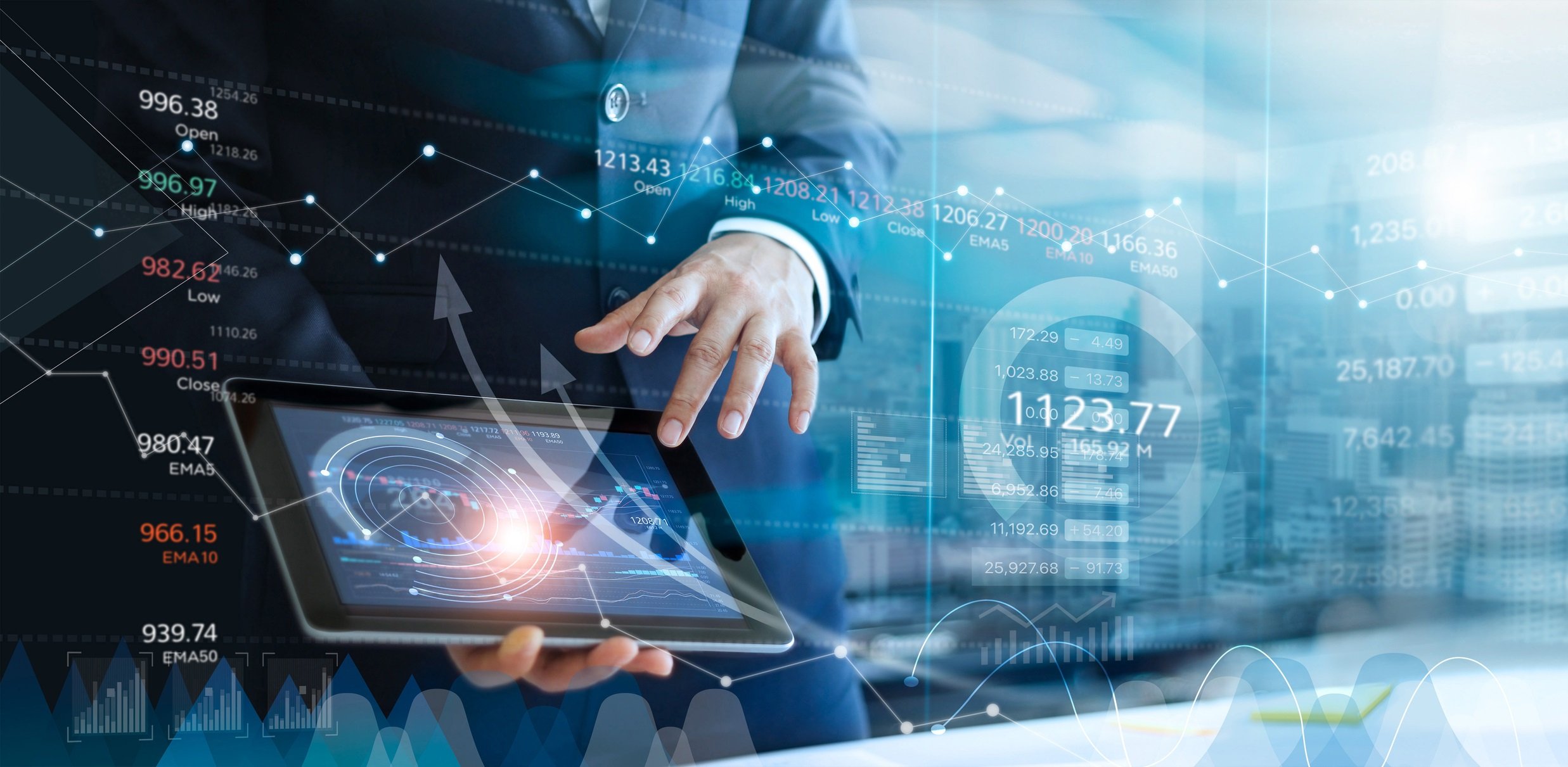 A man uses a tablet as digital graphs are superimposed over the scene.