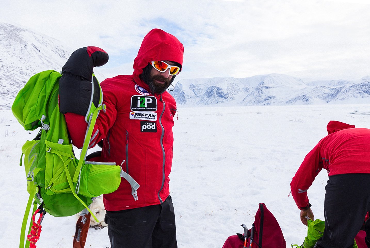 A man wearing warm clothes in an arctic terrain.