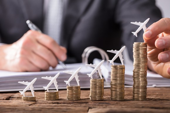 airplanes sitting on top of growing piles of money