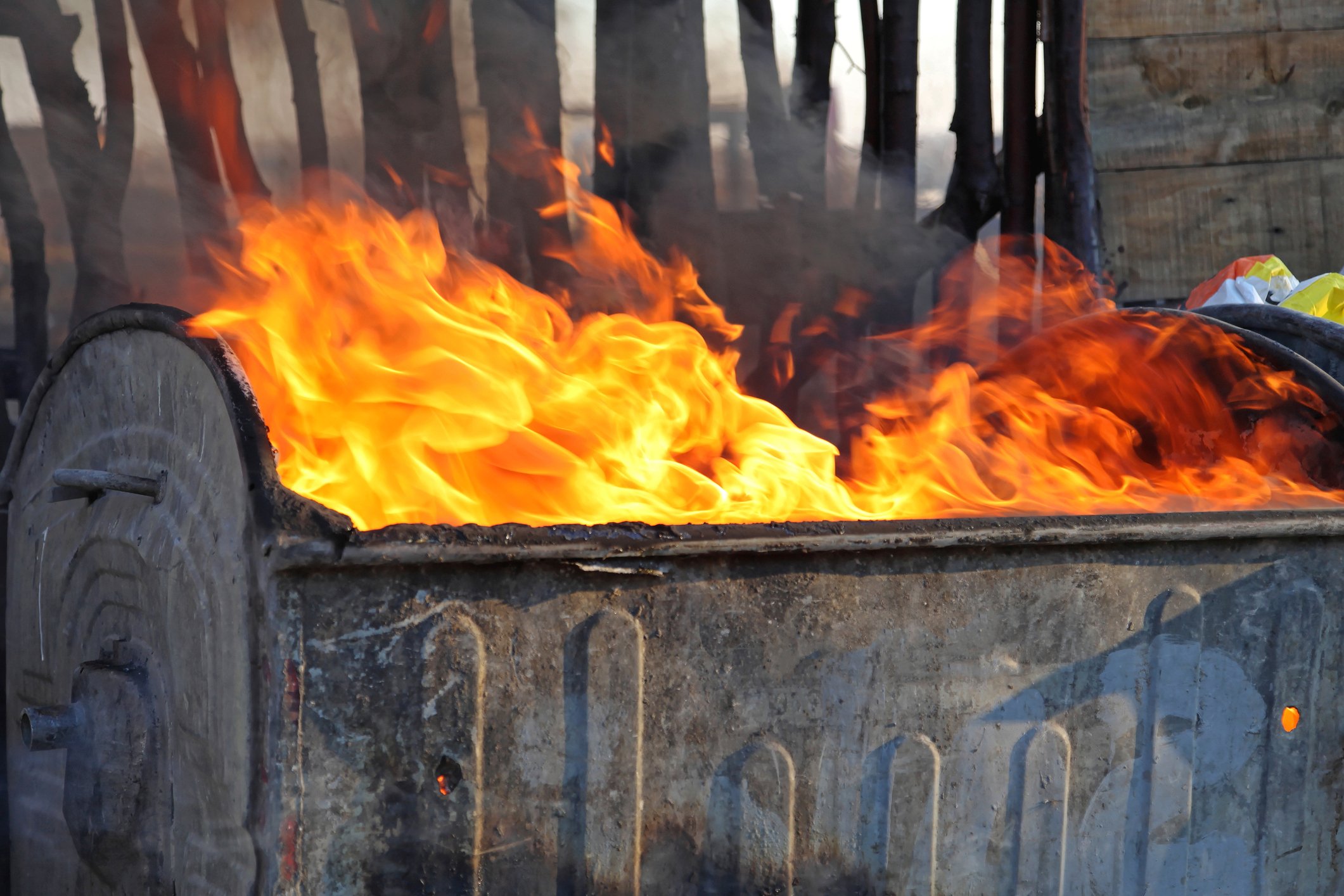 Fire blazing in a garbage dumpster.