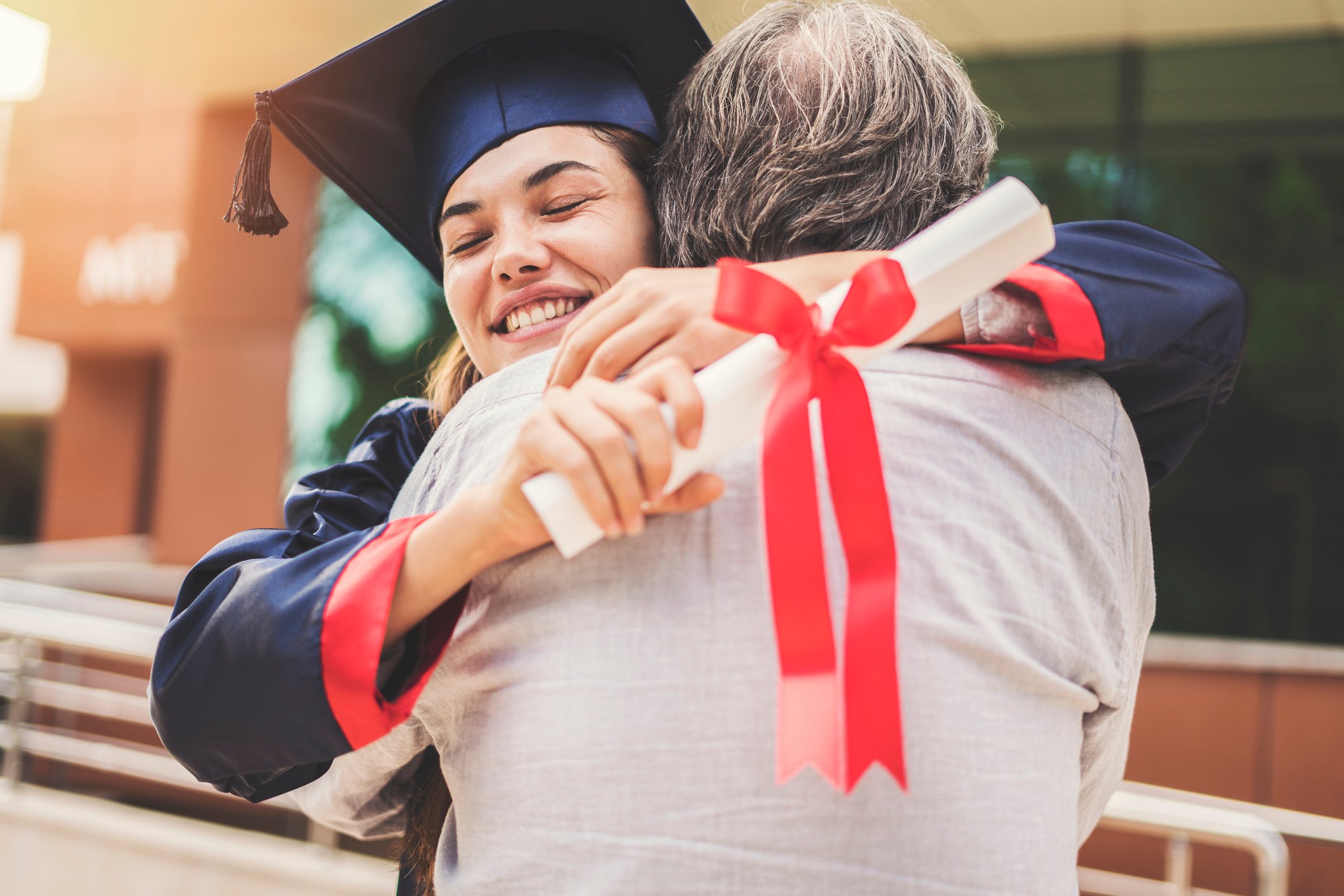 A graduating student hugs her father.