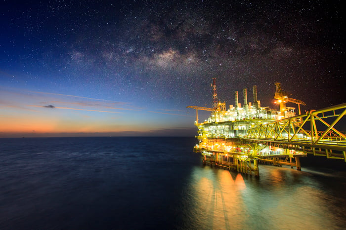 An offshore oil rig lit up at night