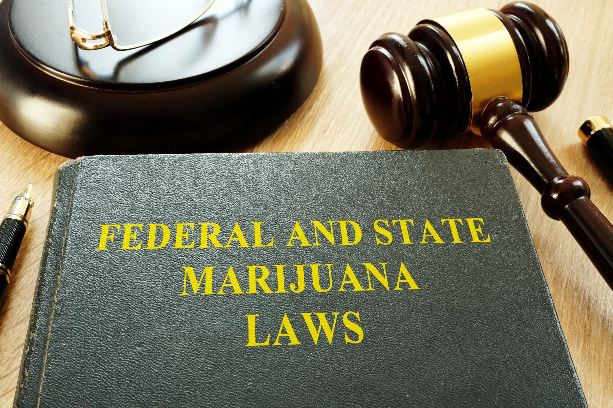 Federal and State Marijuana Laws book next to a judge's gavel