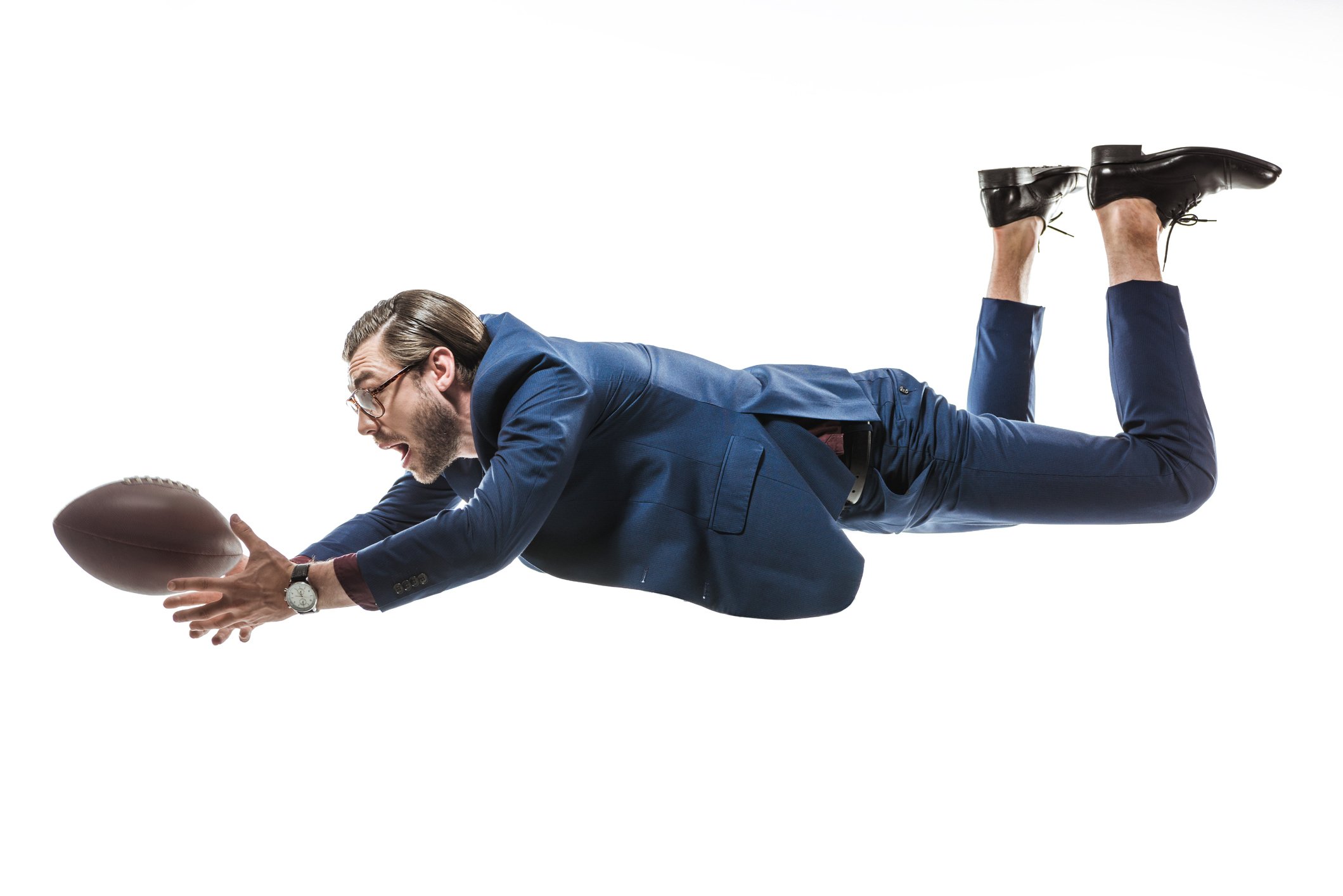 Man in suit fumbling a football