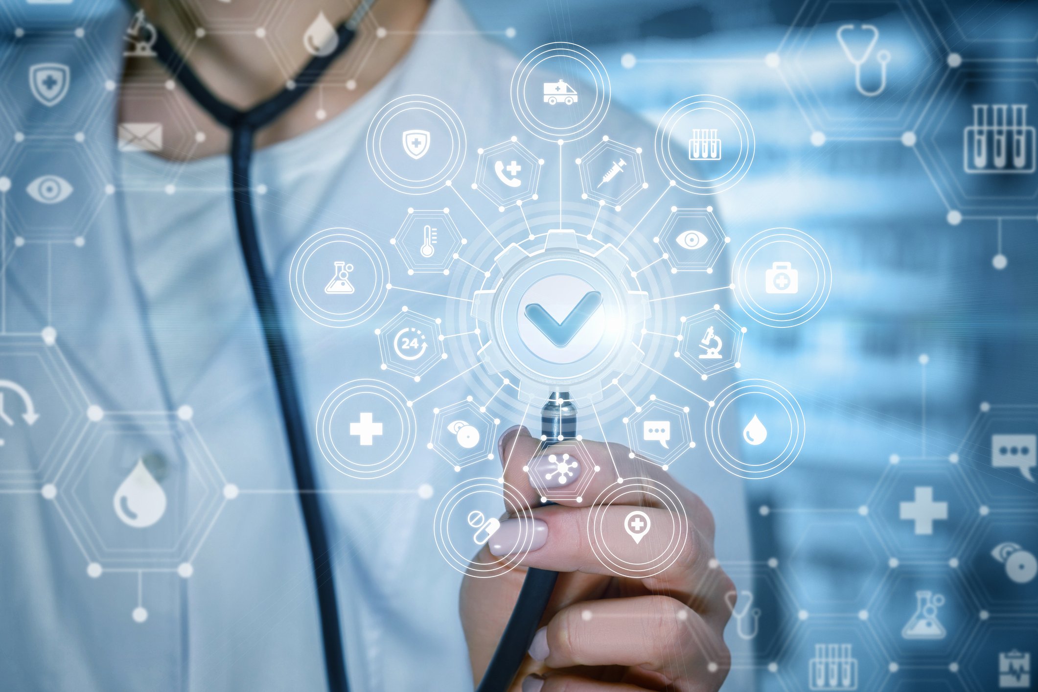 Doctor holding stethoscope up to healthcare-related images