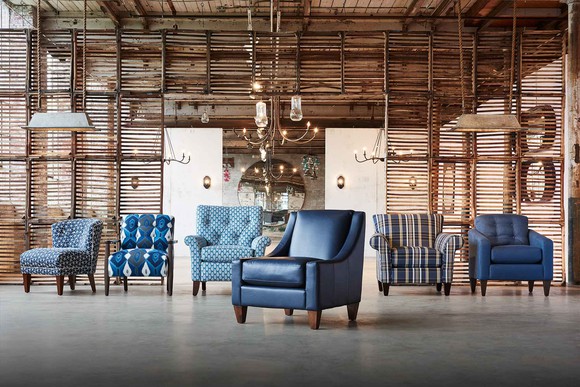 Six chairs in a large room with lamps and a wood wall