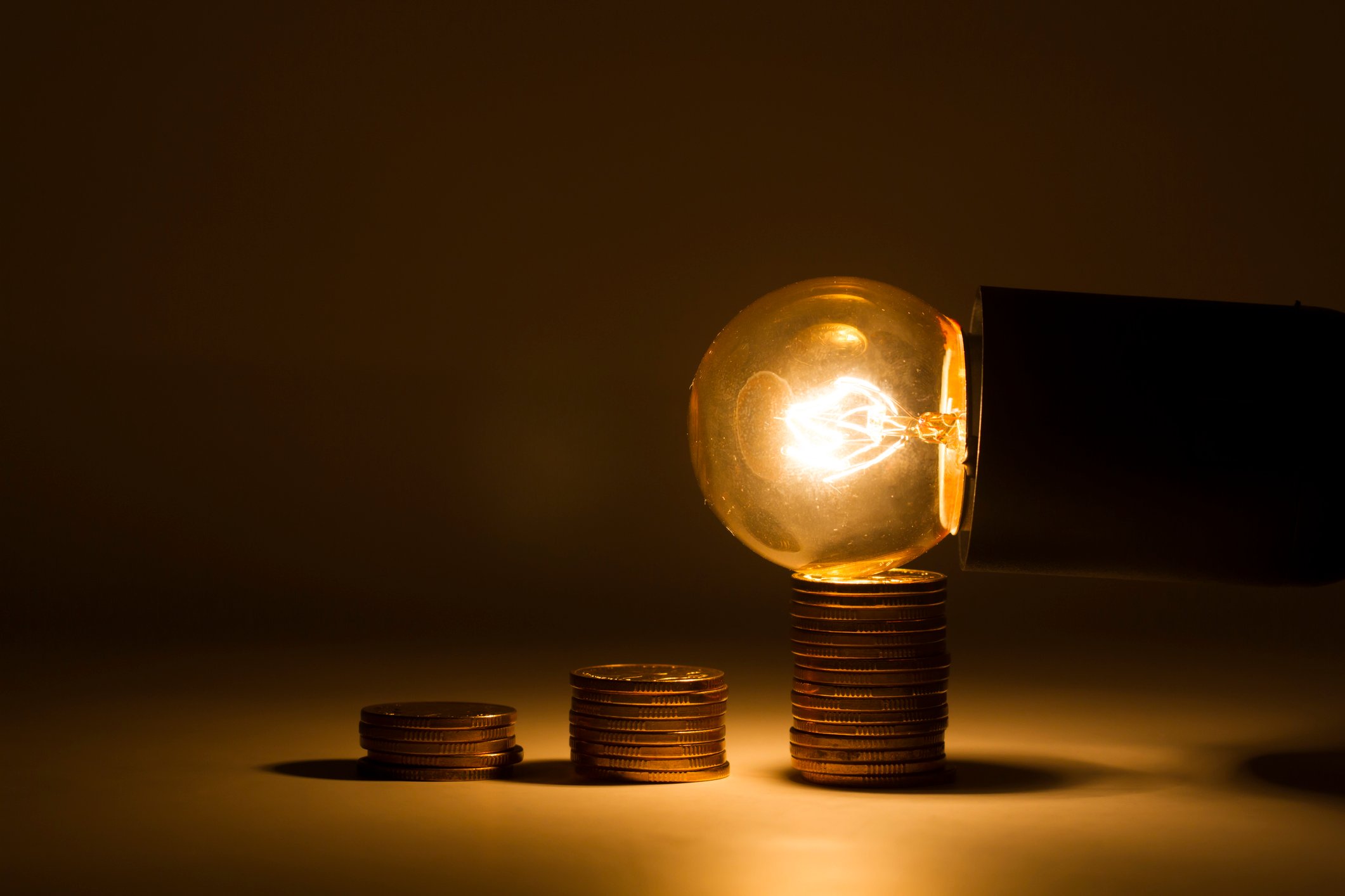 An Edison bulb sits on the tallest of three stacks of pennies