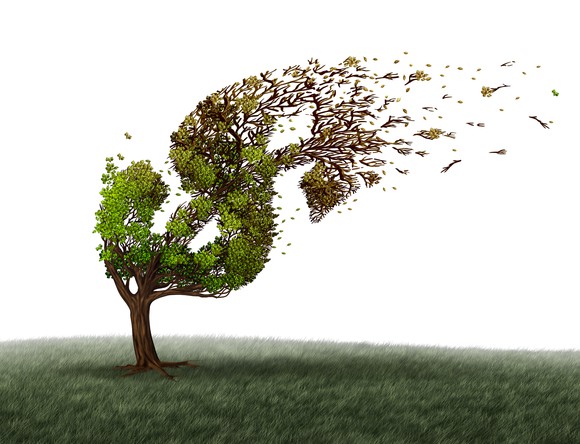Illustration of a tree trimmed in the shape of a dollar sign, bending in heavy wind.