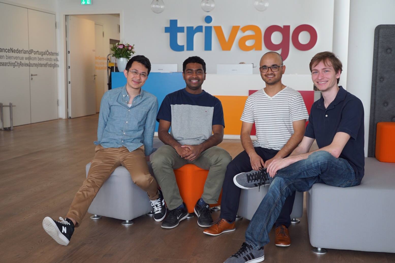 Winners of a Trivago hackathon in front of the corporate logo.