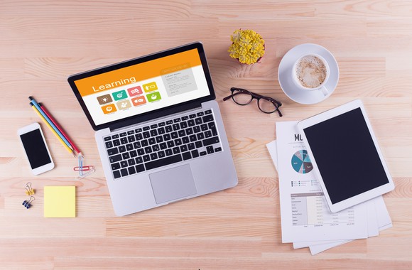 A laptop and schoolwork spread out on a desk