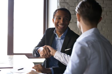 Two Businessmen Shake Hands After Signing a Deal