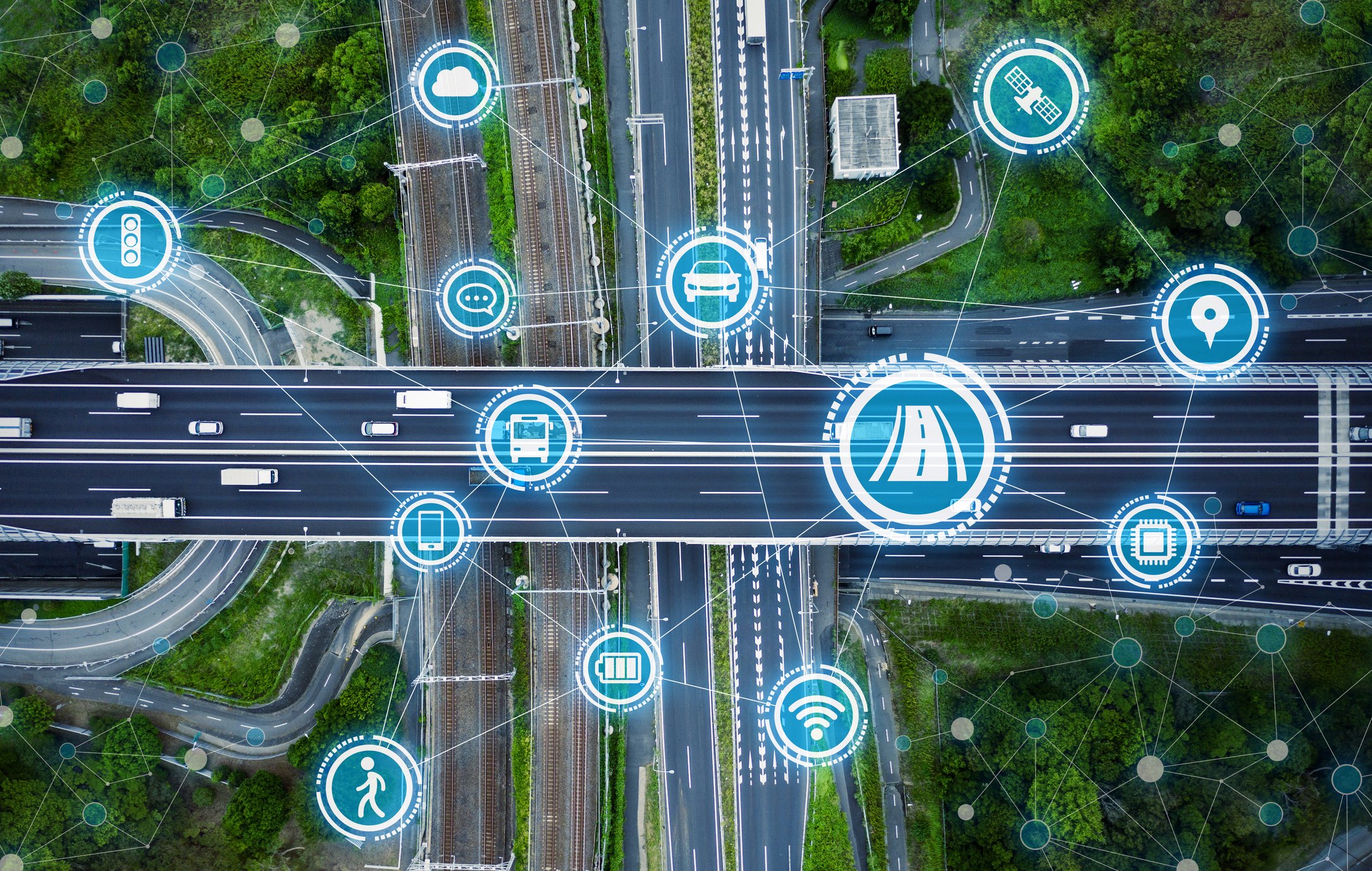 An aerial view of a highway overpass with an overlay of connectivity icons.