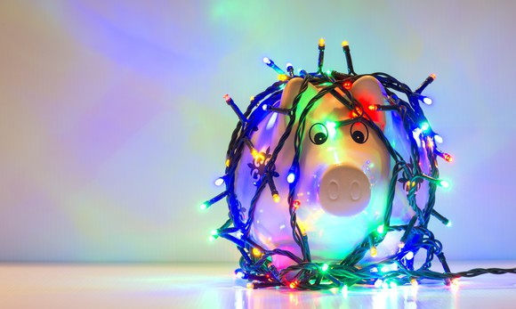 A piggy bank wrapped in Christmas lights