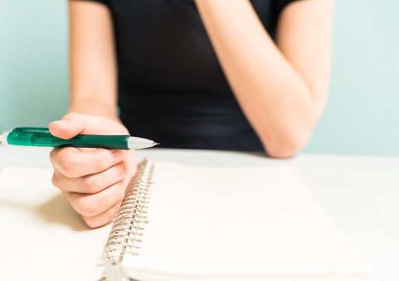 Woman about to take notes on notepad