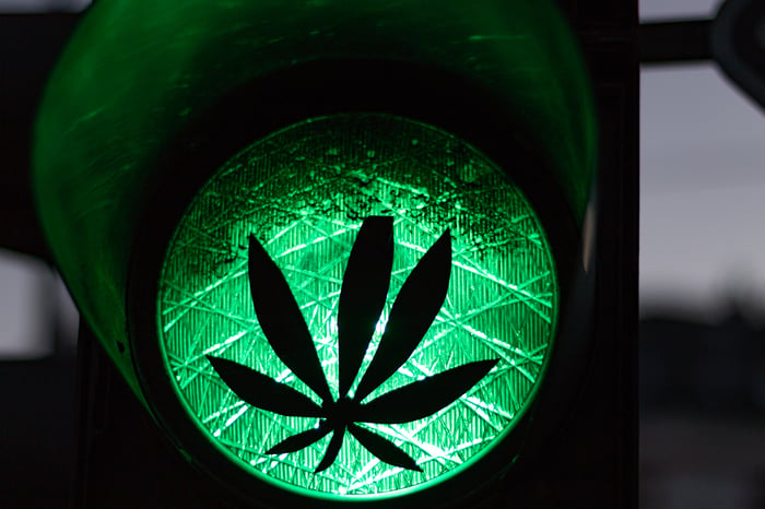 Image of cannabis leaf on a green traffic light