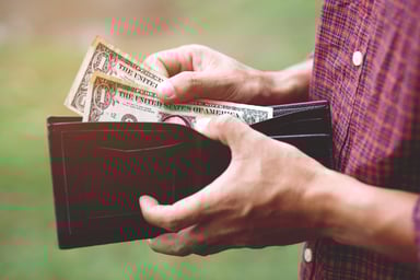 Close Up of Man Pulling Dollar Bills from Wallet