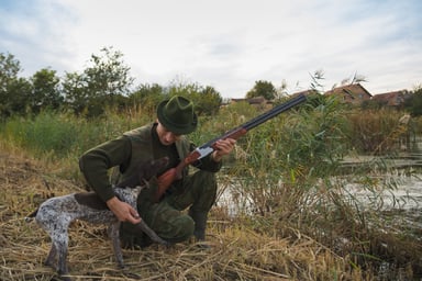 Hunter with riffle shotgun and hunting dog getty