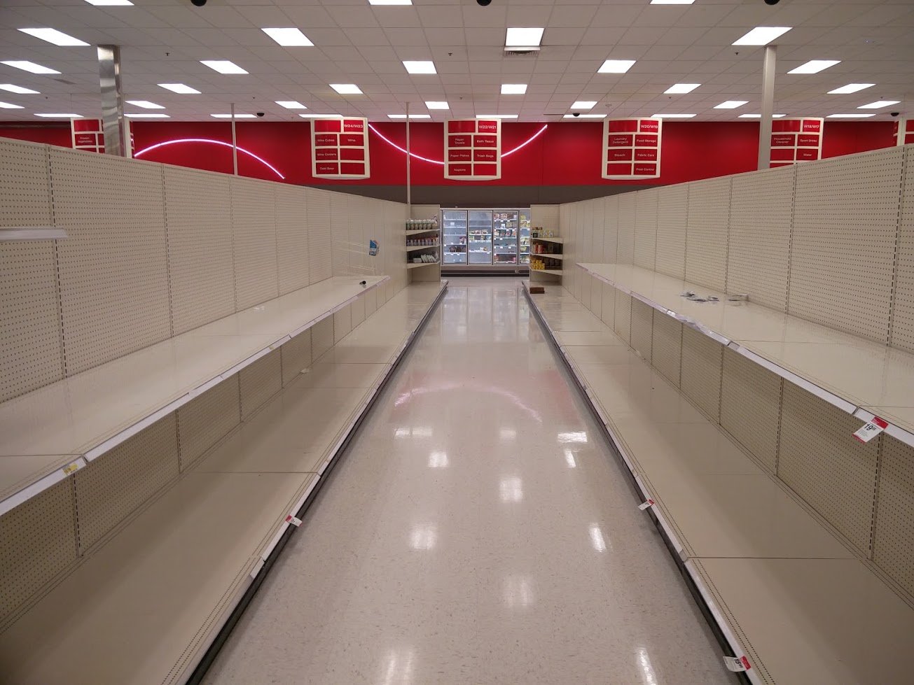 An empty aisle of empty shelves in a soon-to-close-forever retail store