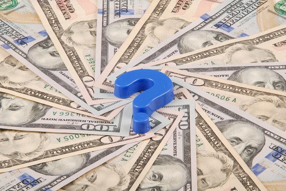 Blue question mark on top of $100 bills