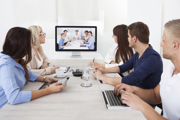 Five employees meeting with five other employees via a Zoom videoconference.
