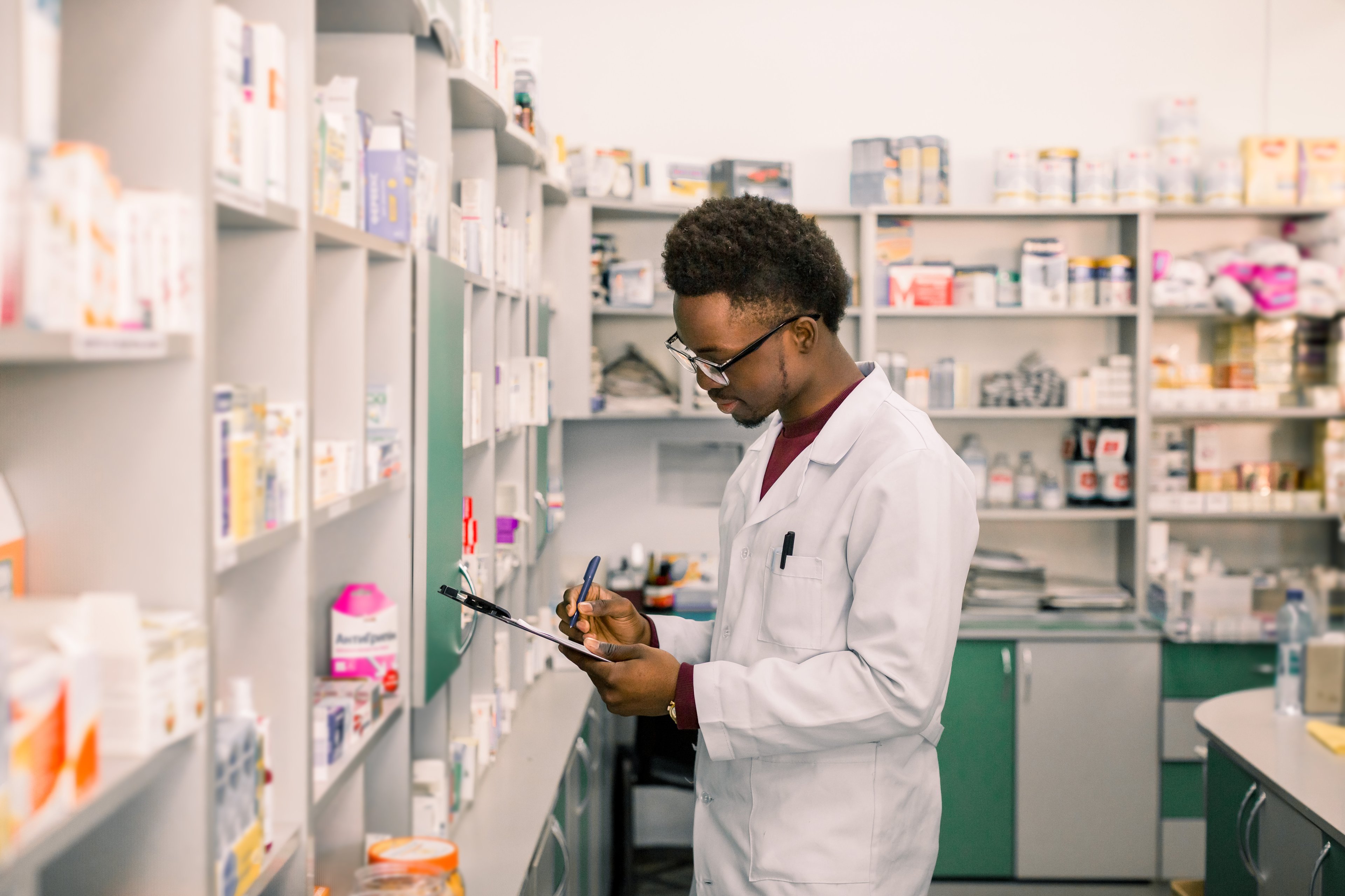A pharmacist writes on a clipboard