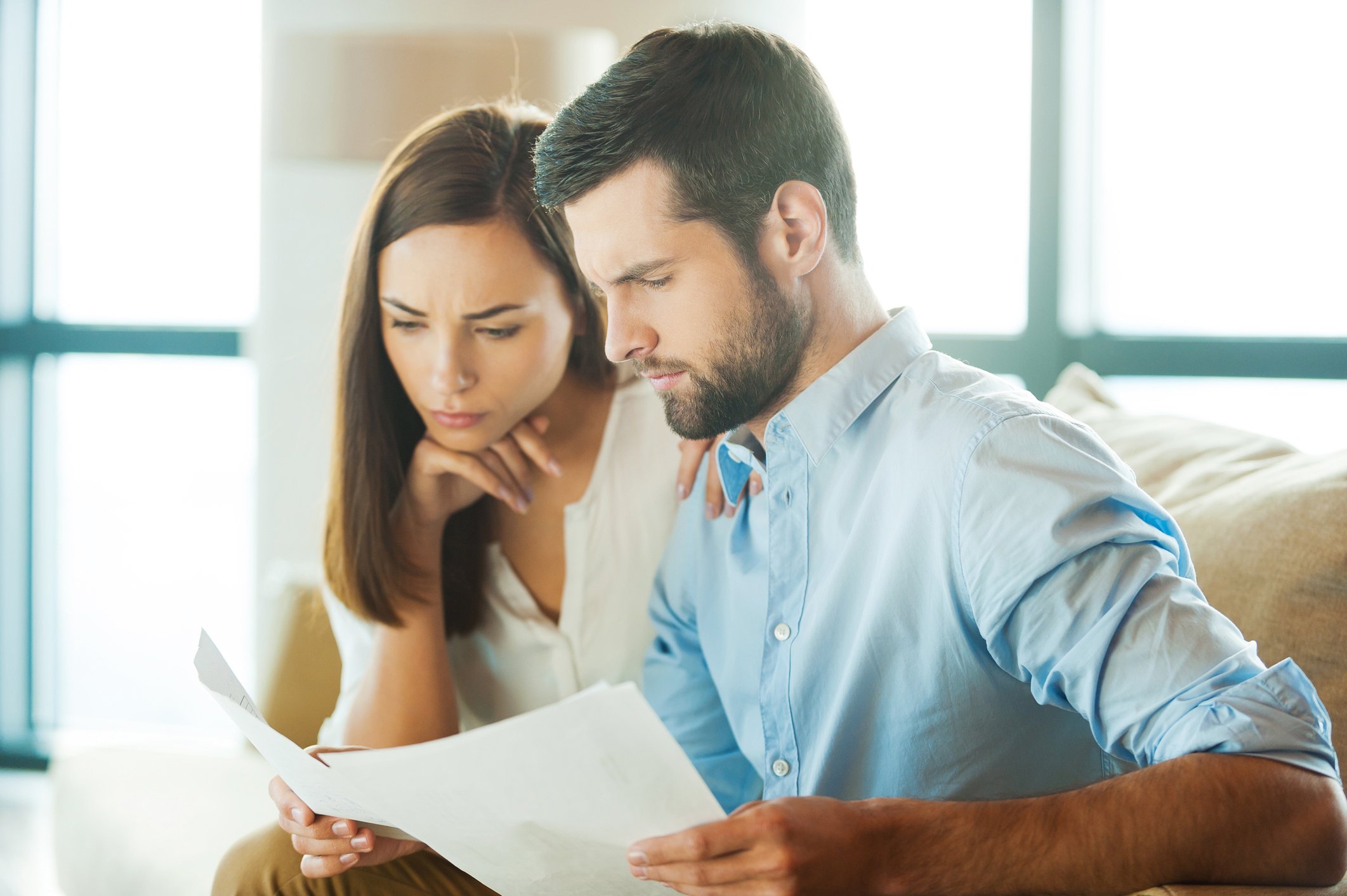 Young man and woman looking at documents with serious expressions