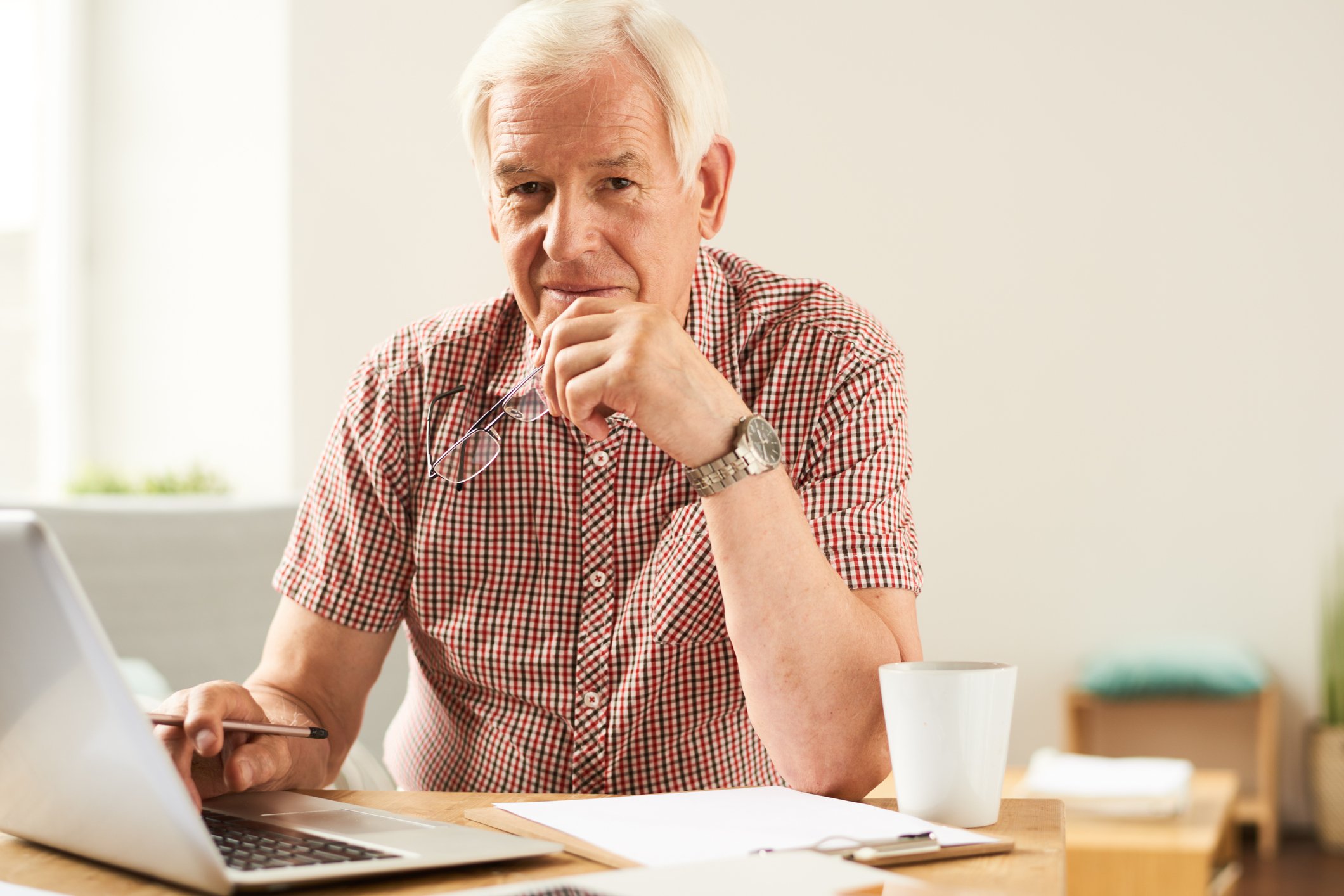 Older man with serious expression at a laptop