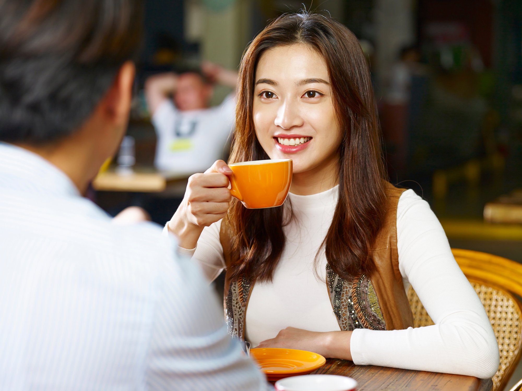 A young woman drinks a cup of coffee.