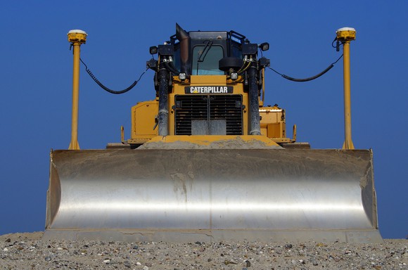 Caterpillar tractor as seen from front, with some sand in front.