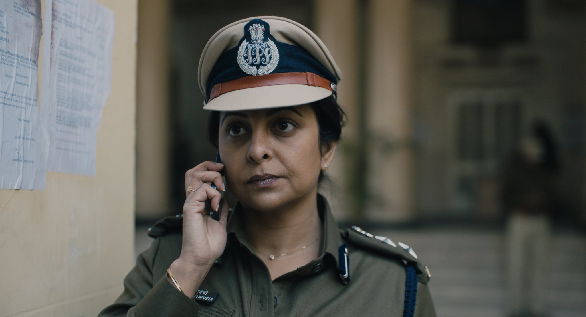 A female police officer in India speaking on a cell phone.