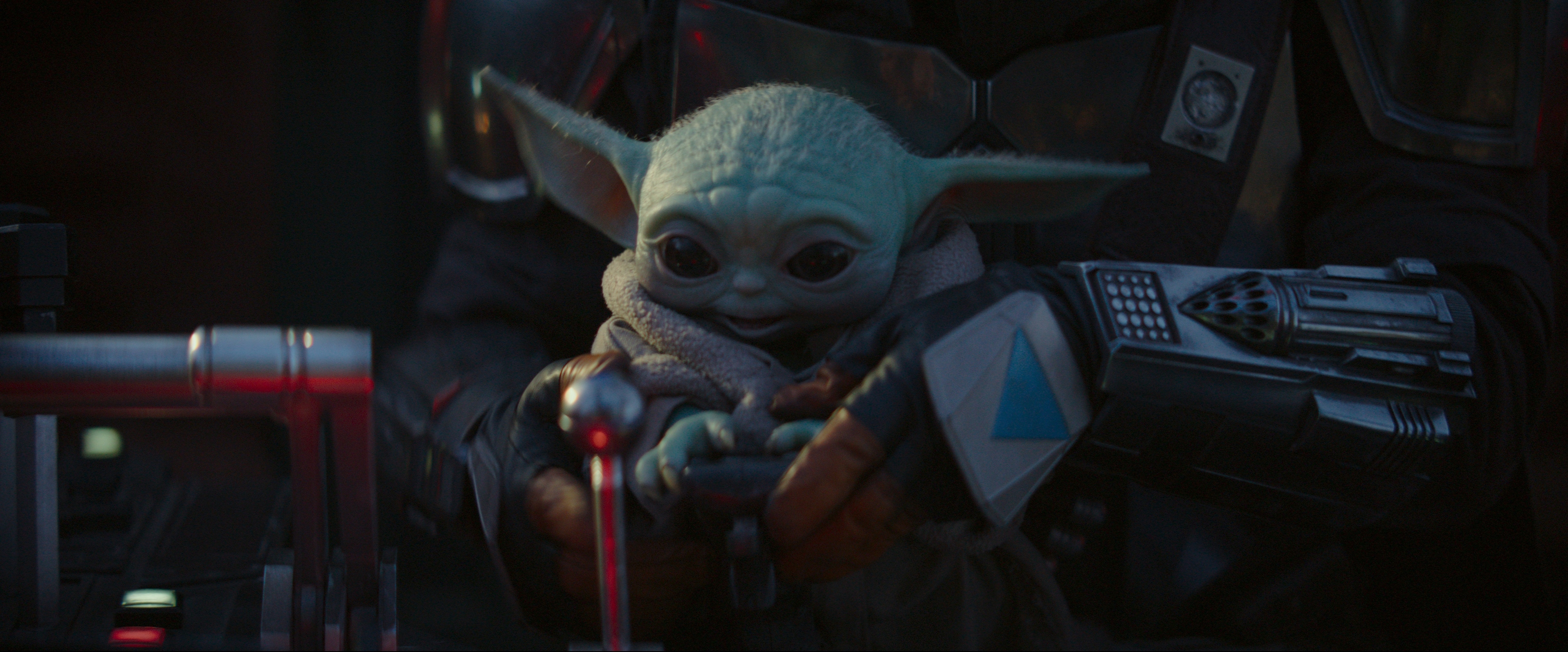 The Child sitting in The Mandalorian's lap