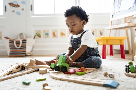 Toddler playing with toy truck.