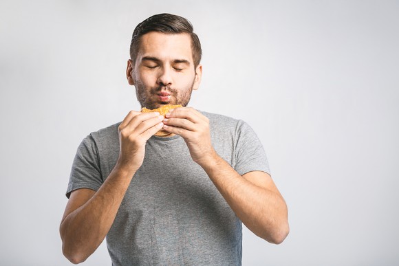 Man holding a hamburger.