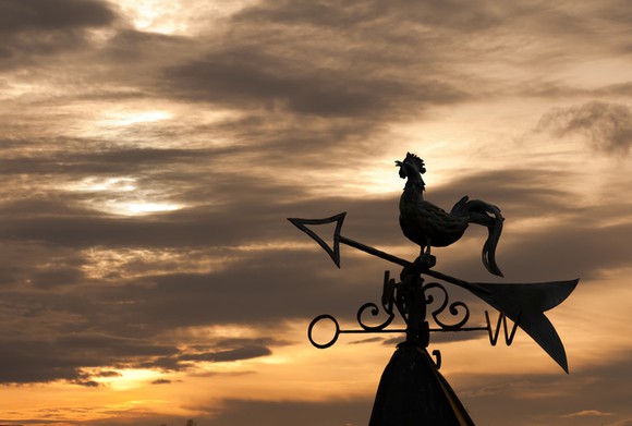 A wind vane against a sunset.