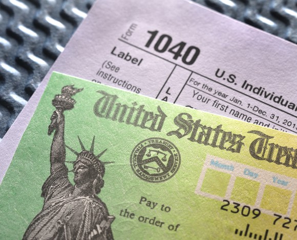 1040 form with tax refund check sitting on top of it.