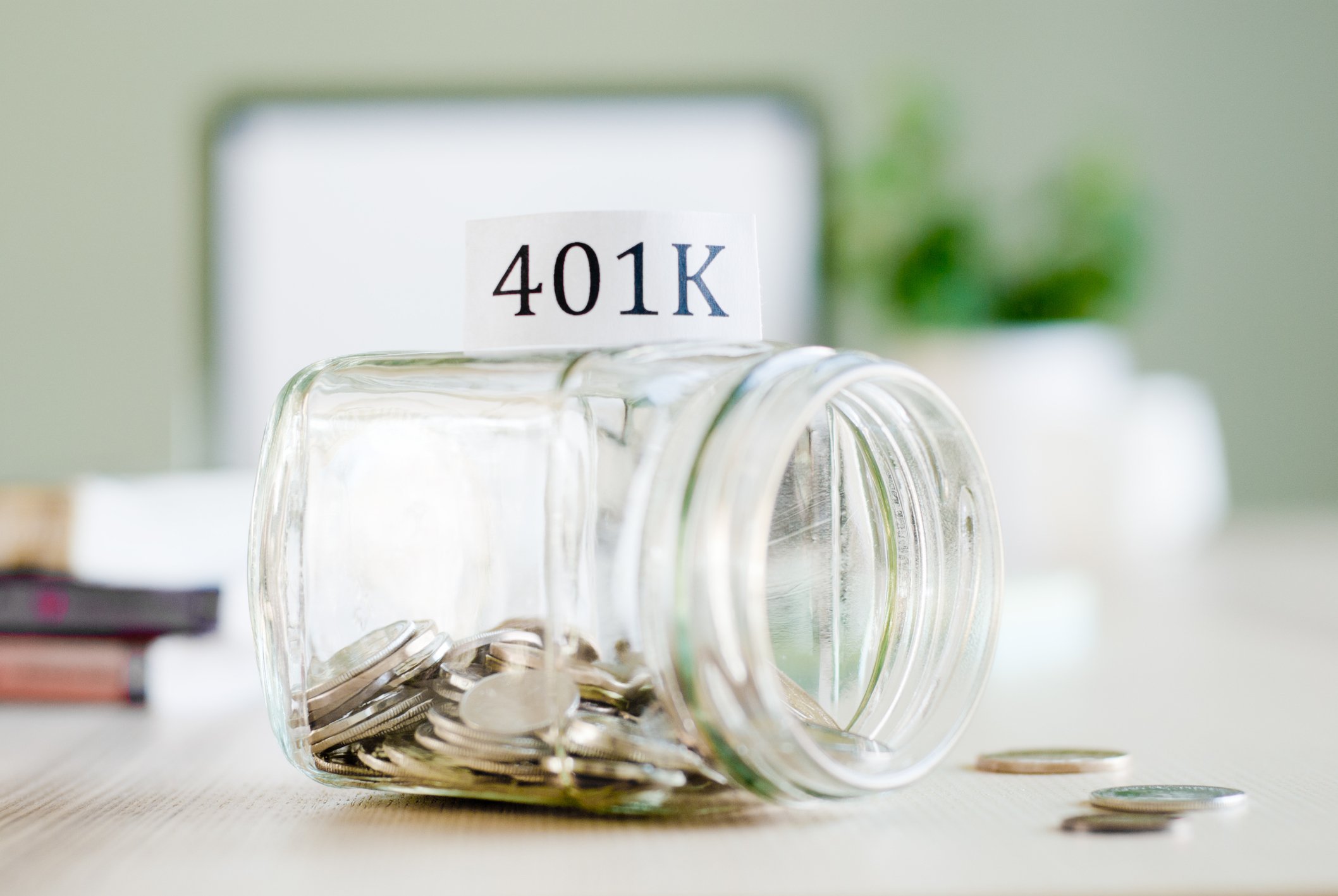 Tipped over money jar labeled 401(k).
