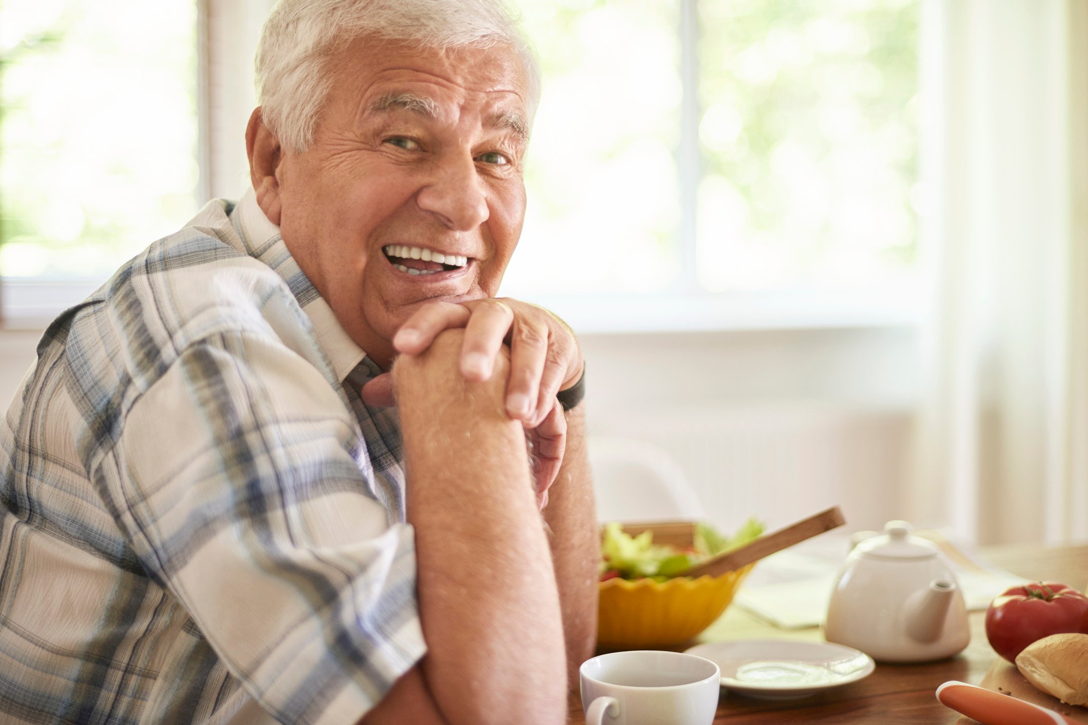 Smiling older man seated at table