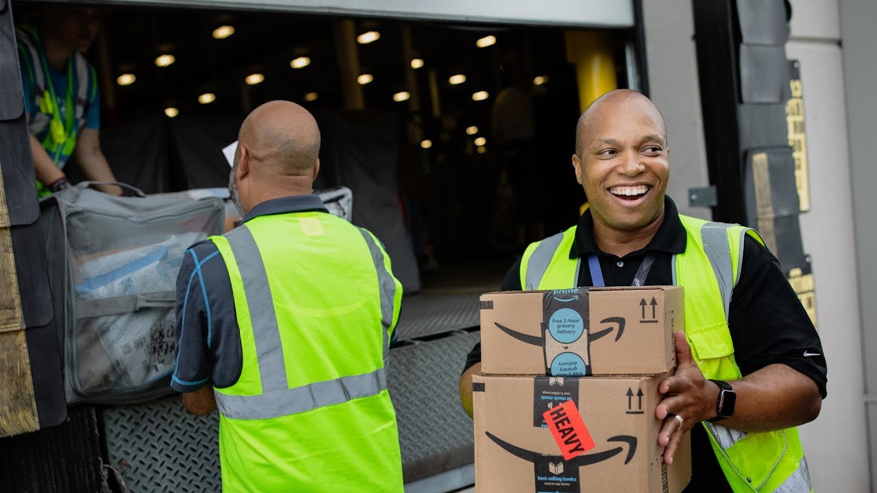 Workers unloading a truck of Amazon boxes