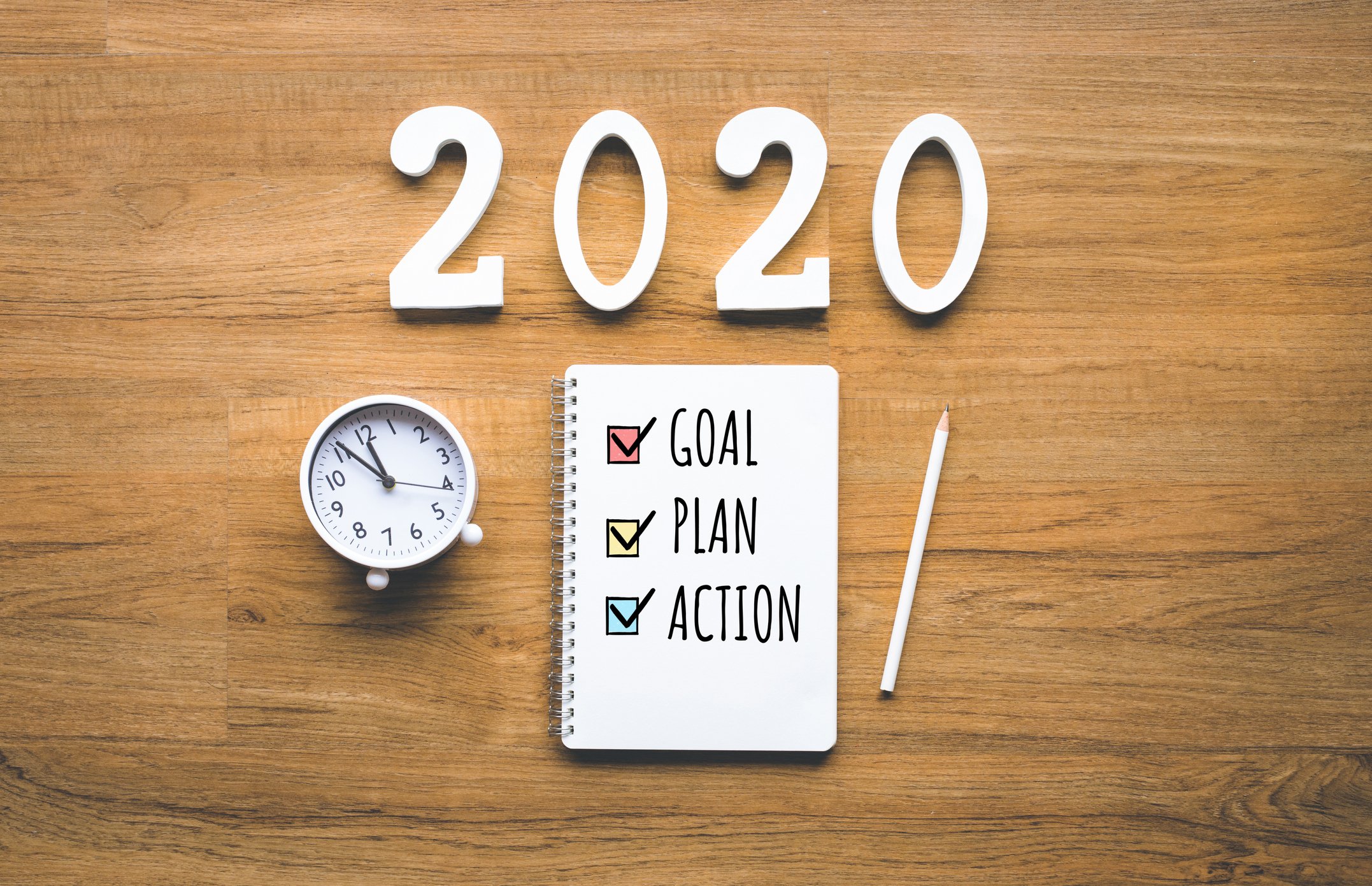 2020 new year goal,plan,action text on notepad on wood background