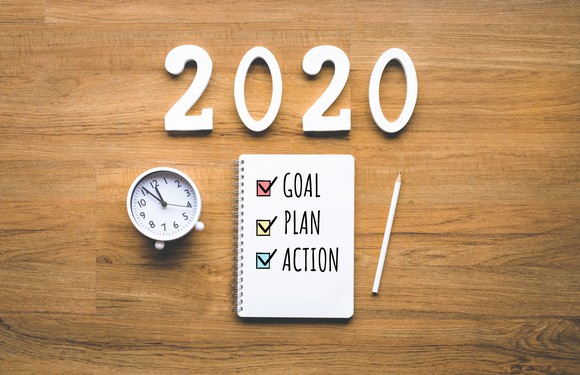 2020 new year goal,plan,action text on notepad on wood background