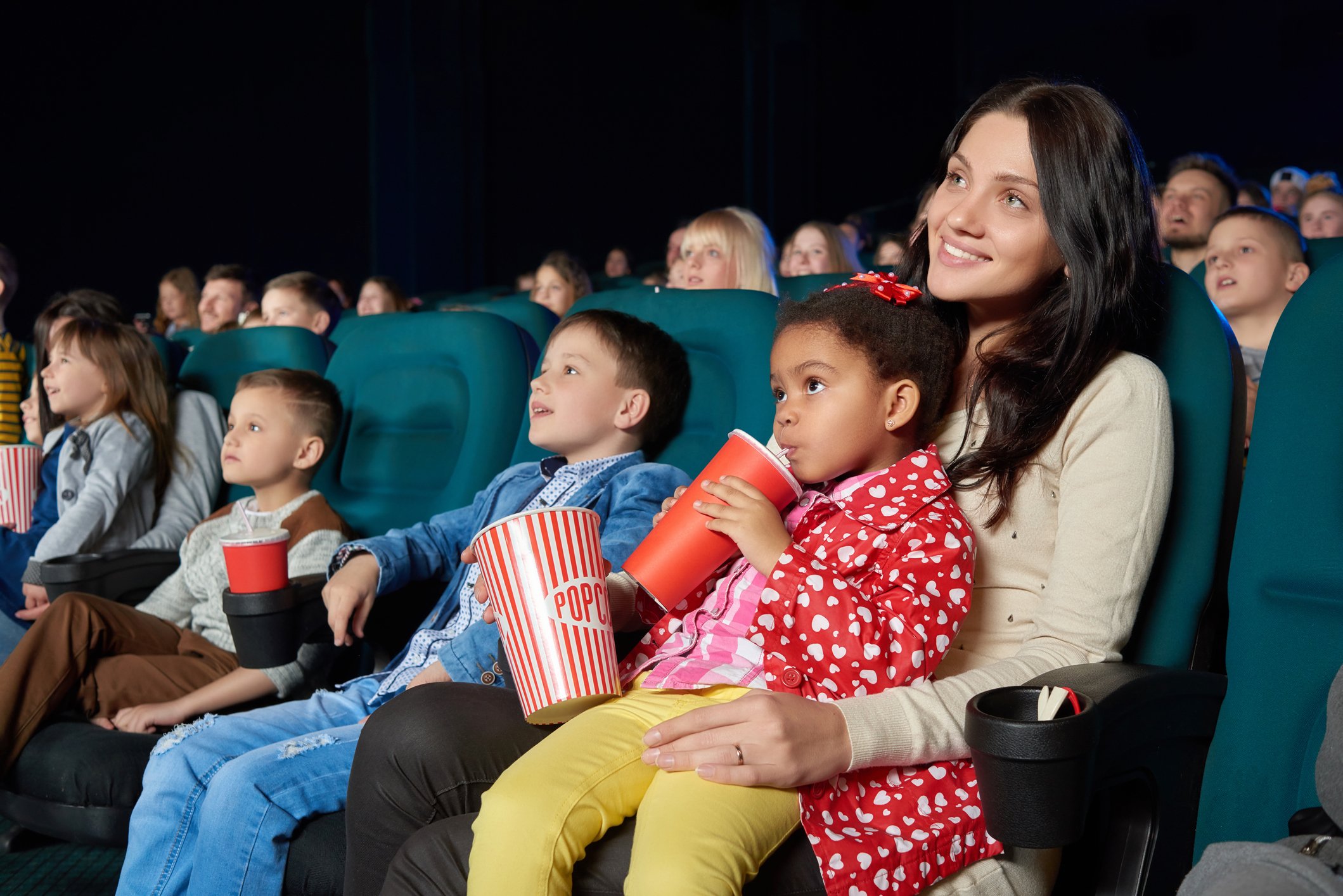 Kids watching a film in a movie theater.