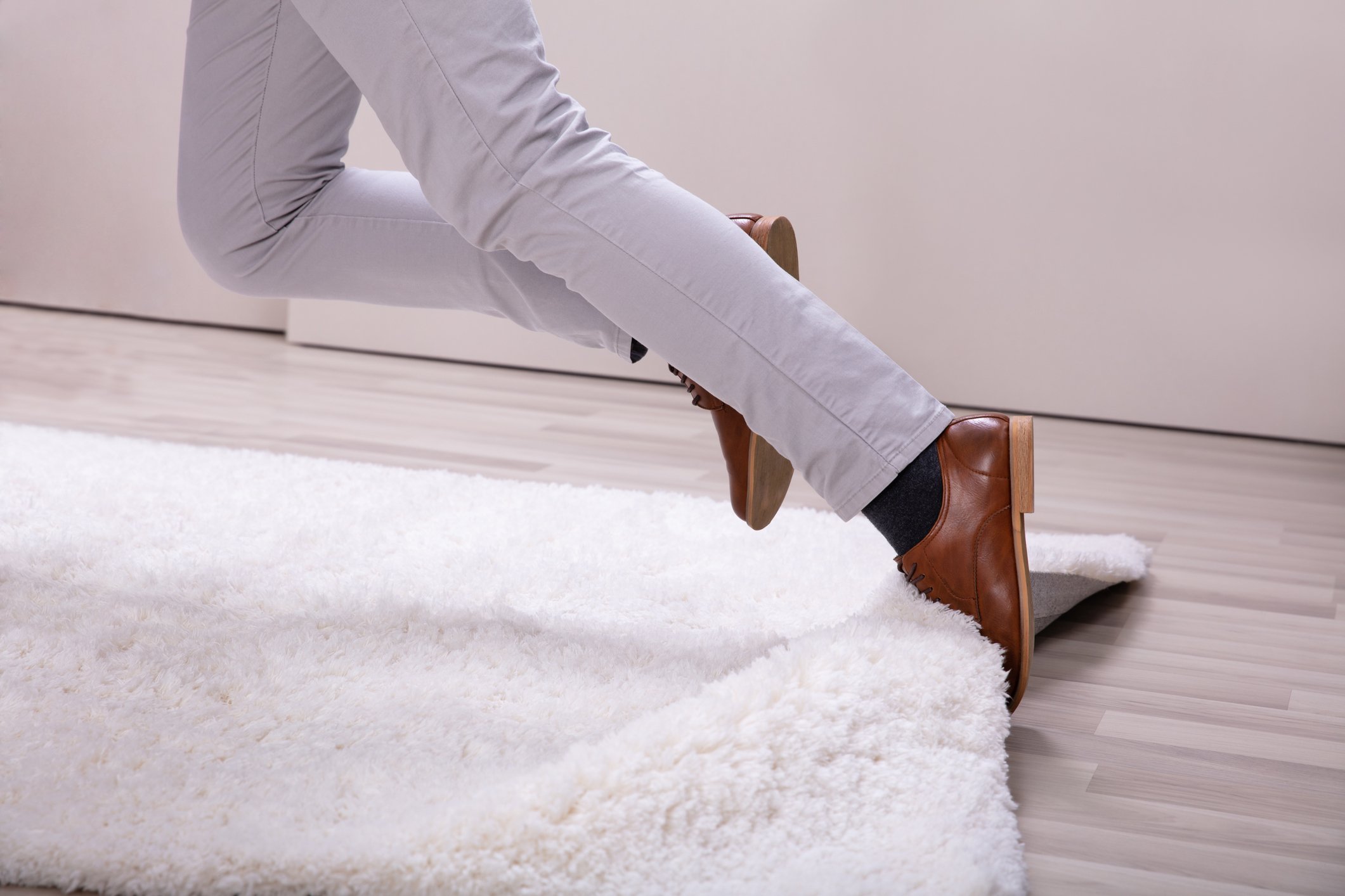 A person tripping on a rug.