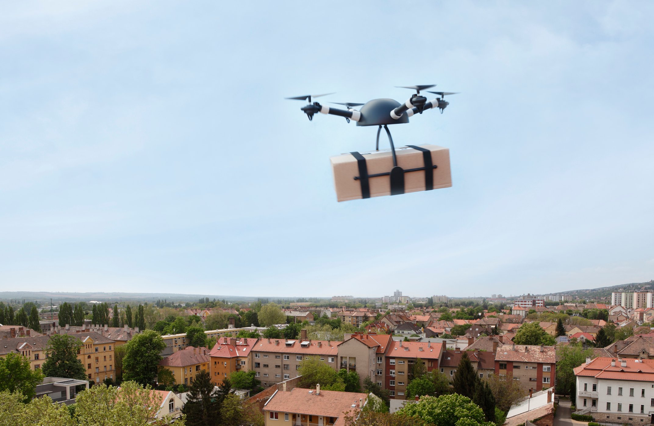 Drone delivering package over city