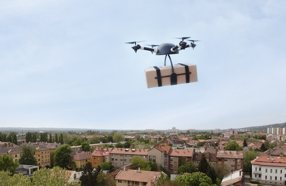 Drone delivering package over city
